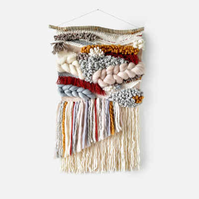 light beige and red woven wall hanging with long tassels